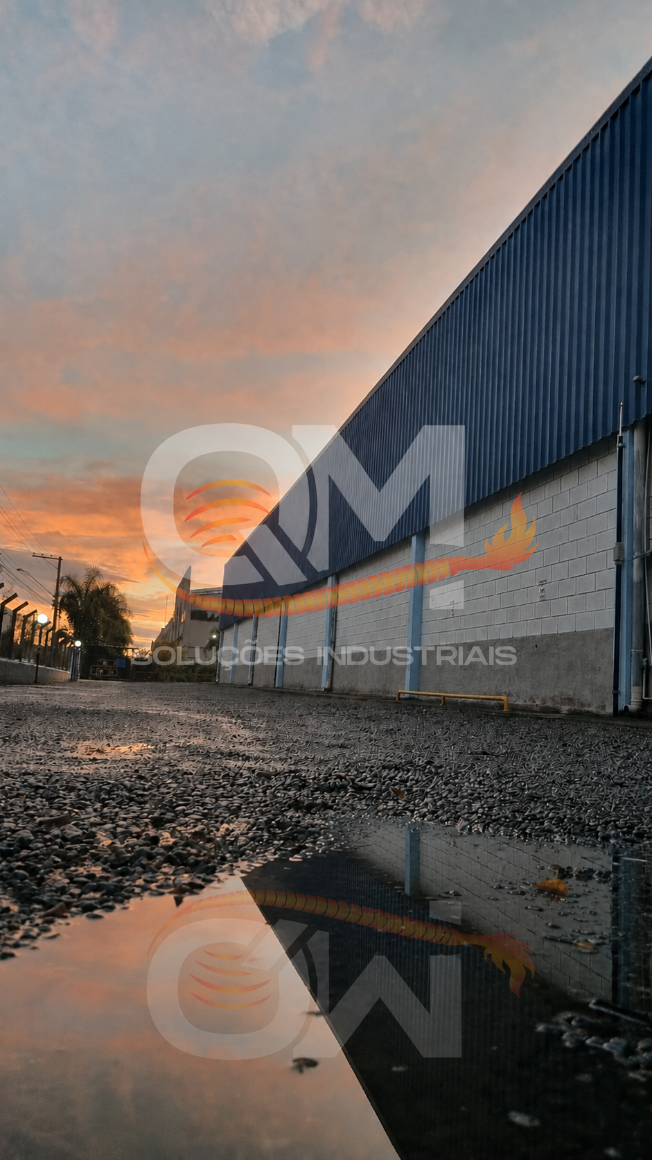 Fachada da fábrica do Grupo QM Soluções ao entardecer